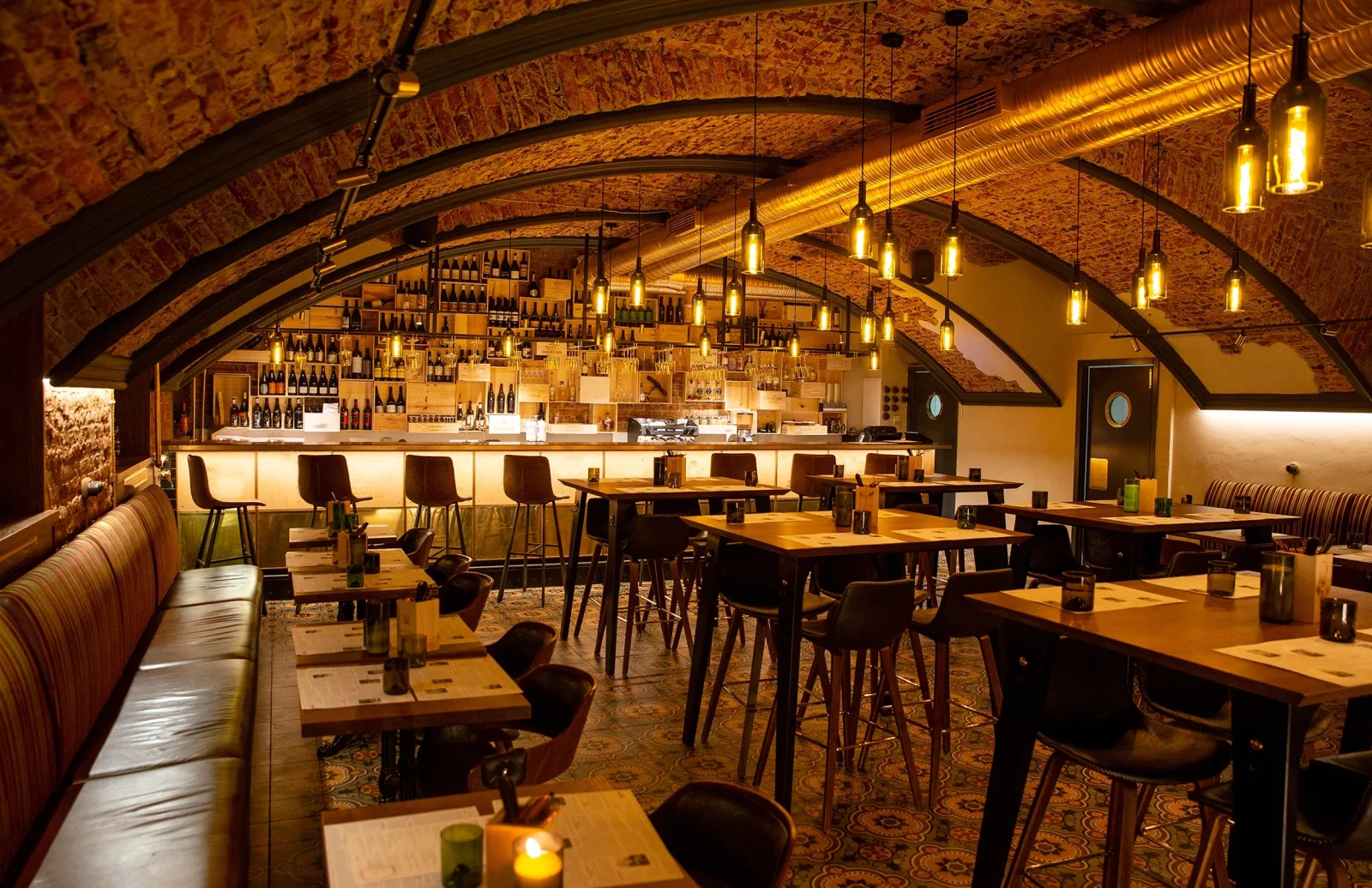 a vaulted brick cellar bar with tables and pendant lighting — how to reach a licensed agent
