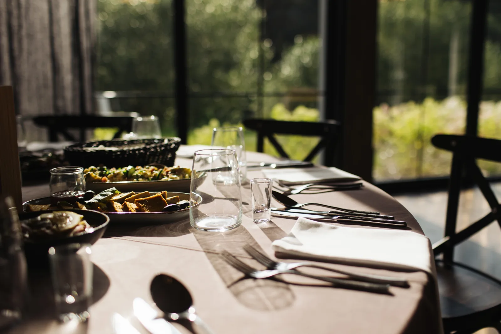 a laid table beside a window with cutlery, glassware and shared serving dishes — restaurant insurance in Michigan
