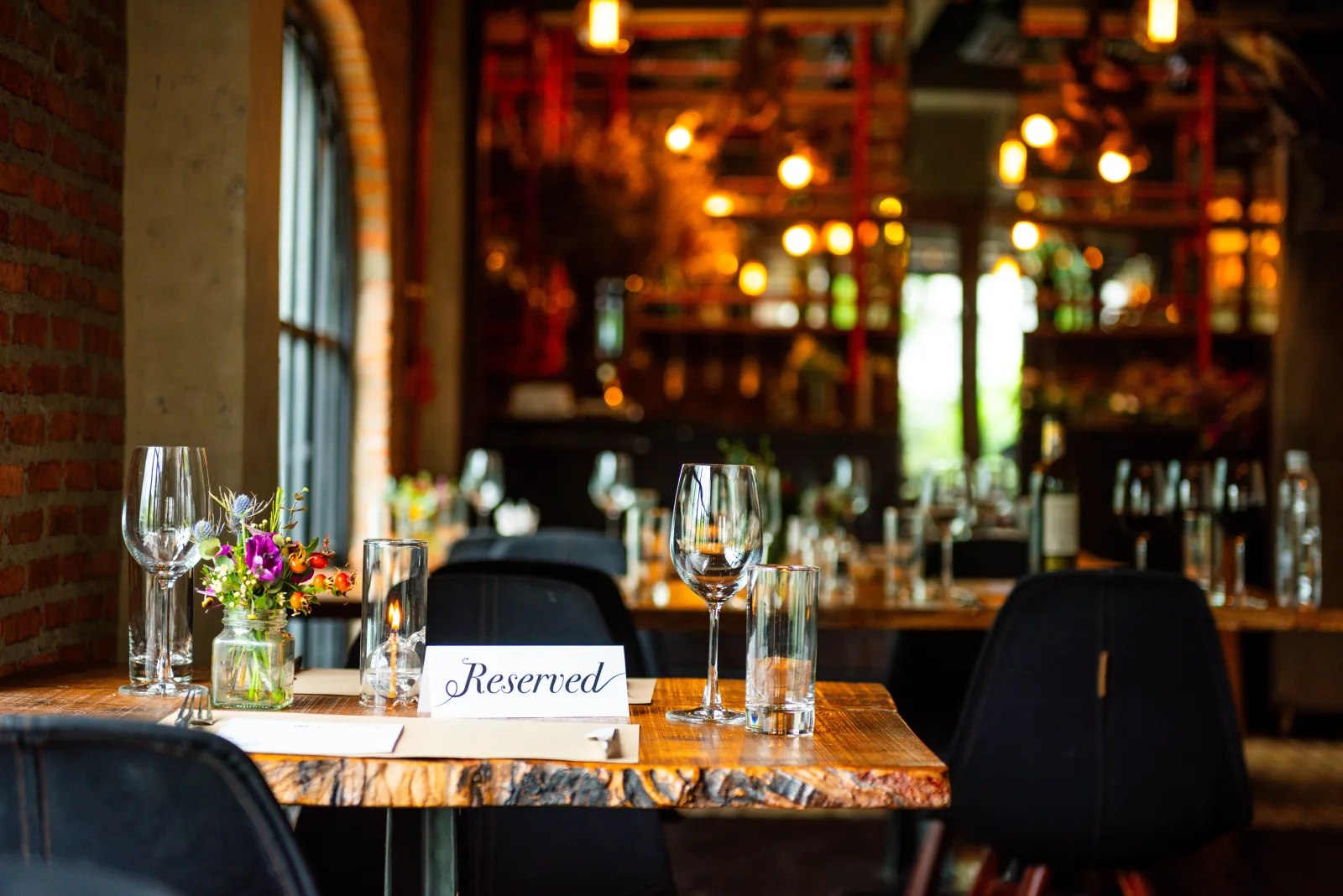 a table laid with wine glasses and a reserved card in a brick-walled dining room — restaurant insurance in Virginia
