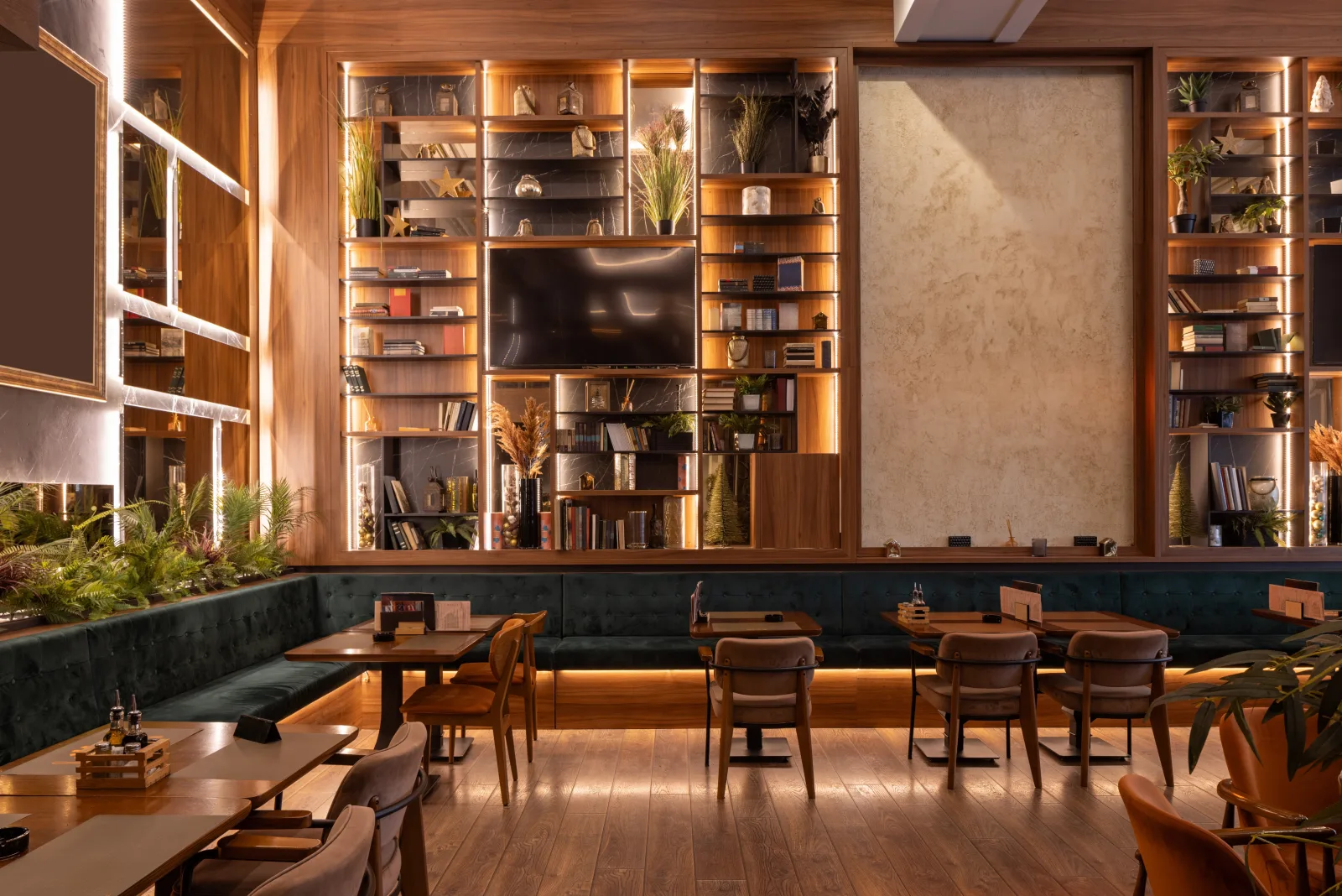 a lit timber shelving wall holding plants and objects above banquette seating — restaurant insurance in Ohio