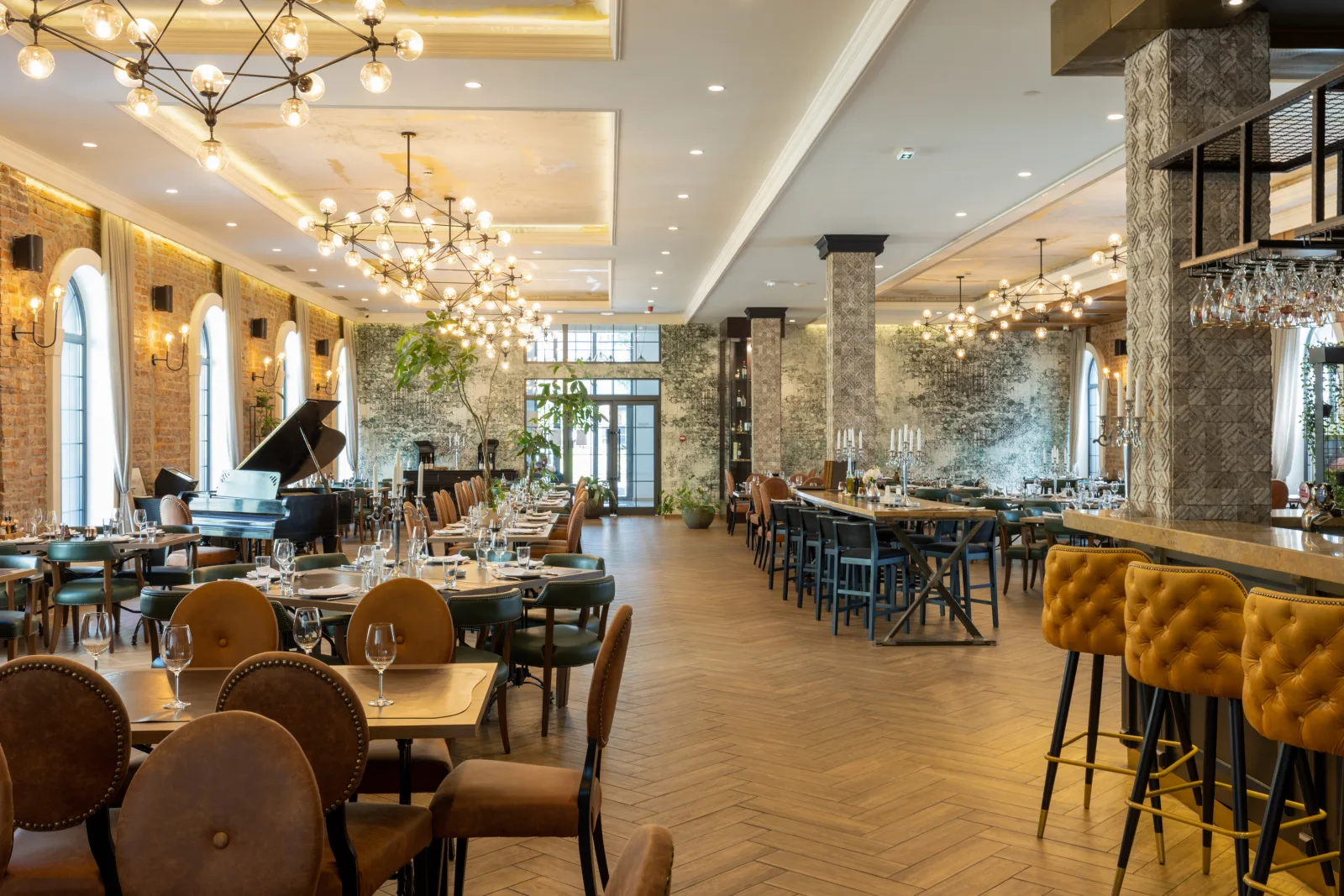 a large dining room with chandeliers, arched windows and a bar along the far wall — restaurant insurance in Maine